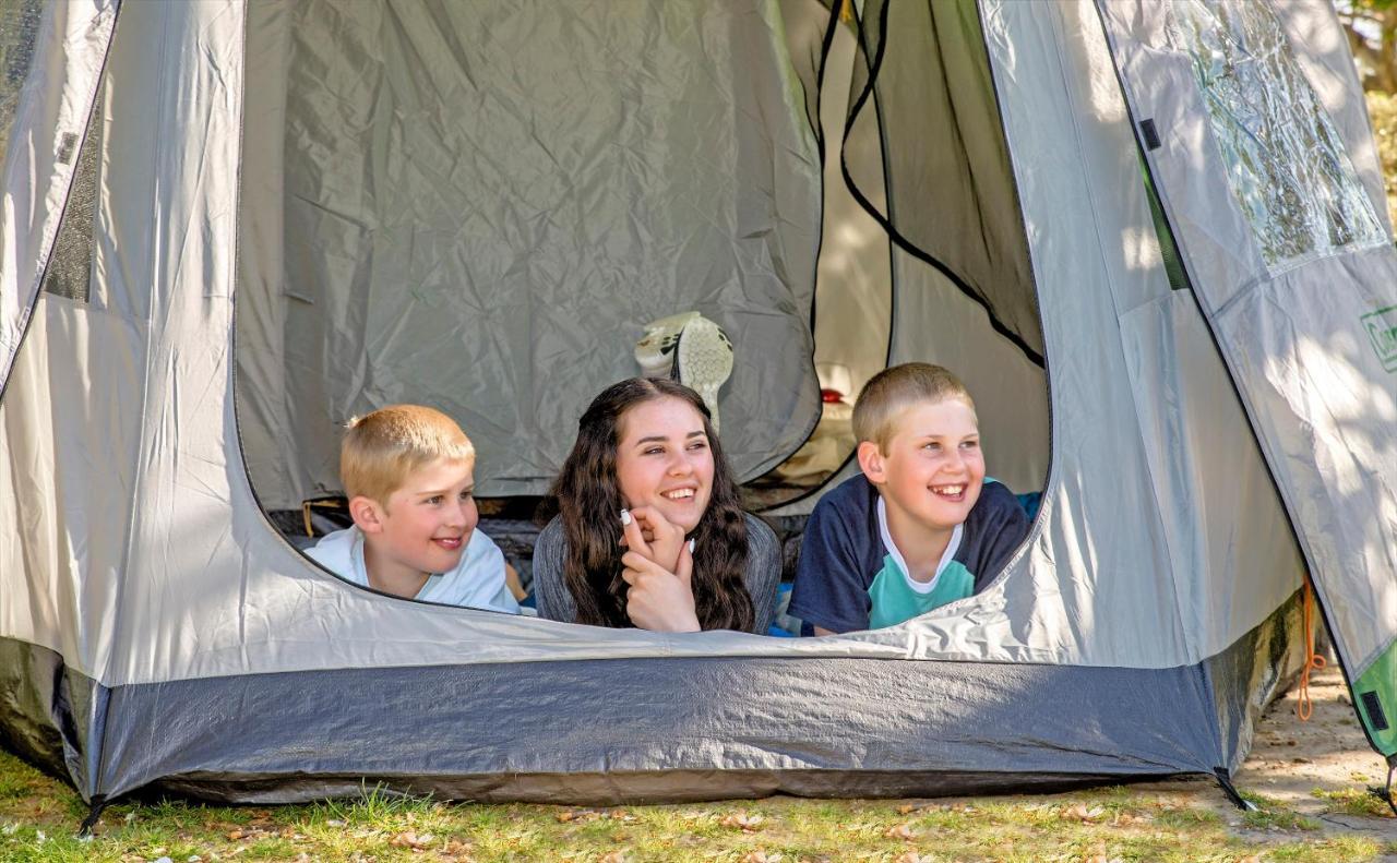 Taupo Debretts Spa Resort Екстериор снимка The photo shows three children inside a tent, looking out from an opening. Two boys are on the left, one with short blonde hair and the other with light brown hair, while the girl in the middle has long dark hair. They all appear to be happy and enga